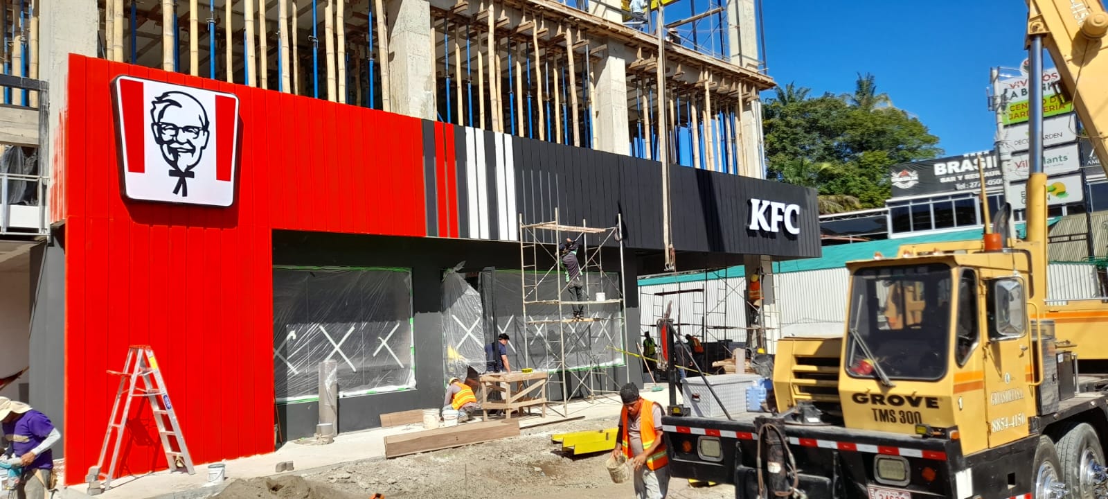 Fachada del local KFC en instalación con revestimiento rojo y letrero iluminado